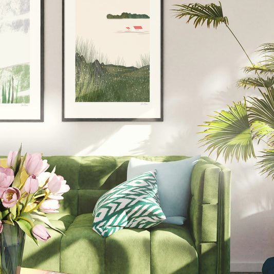 Quiet Meadow art print framed on a wall above a green velvet sofa with tropical plants, OAM Studio. Green sofa with decorative pillows and a vase of pink tulips in a room with framed artwork and a plant.