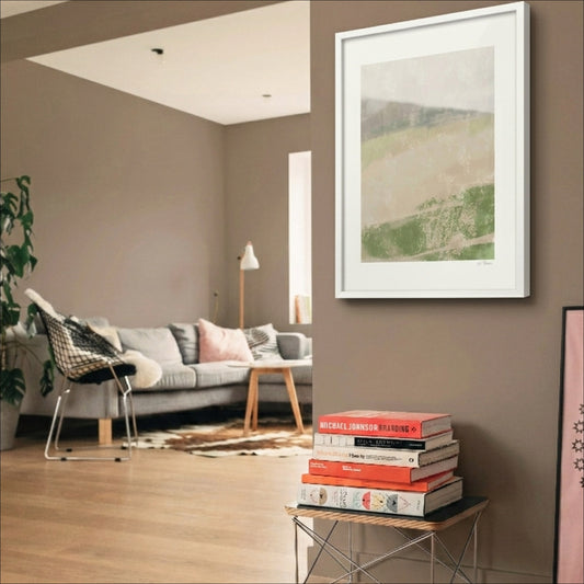Soft Ground art print in a white frame on a dark brown wall beside books in a modern interior, OAM Studio