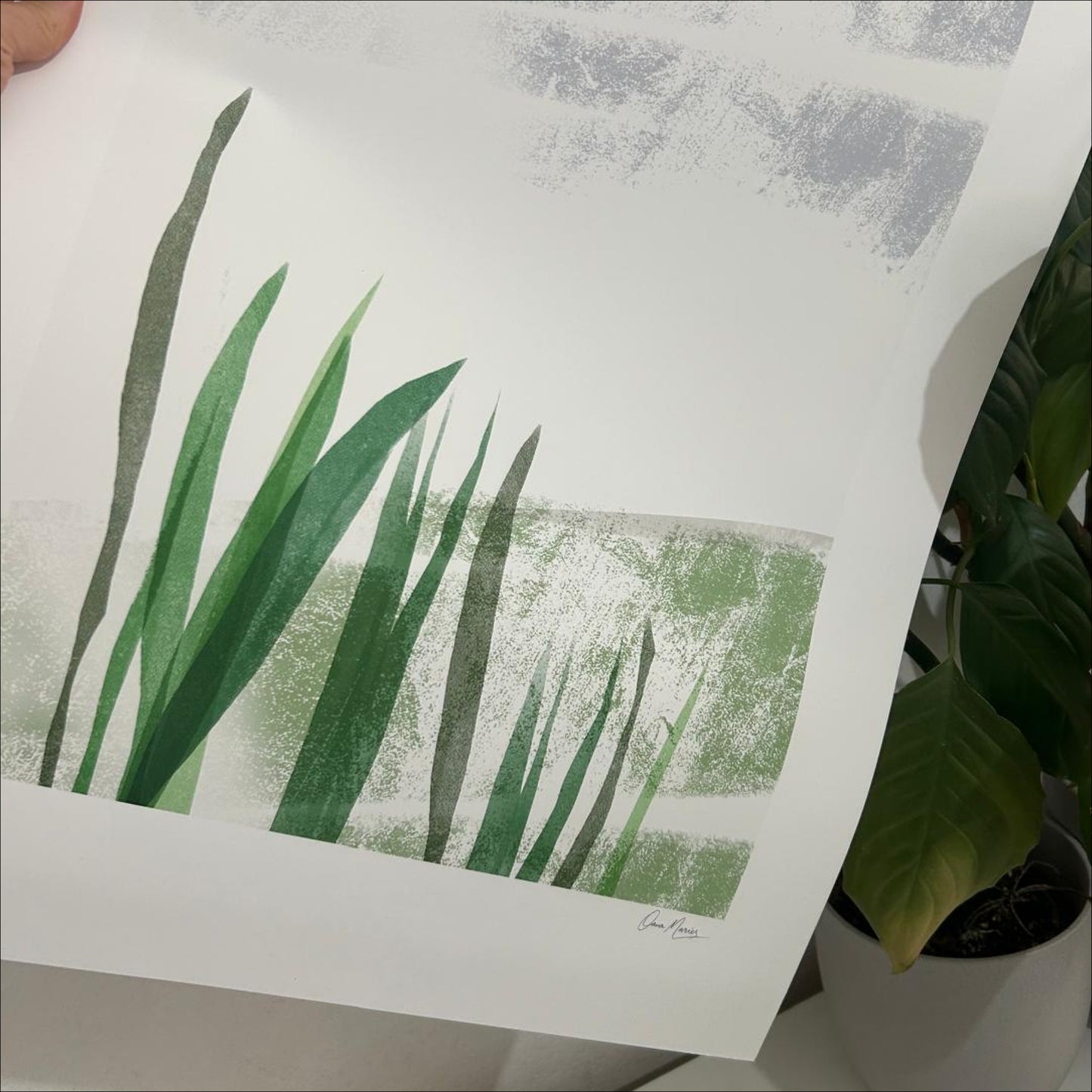 Close-up of Held by the Field art print showing green grass blades and layered texture, OAM Studio