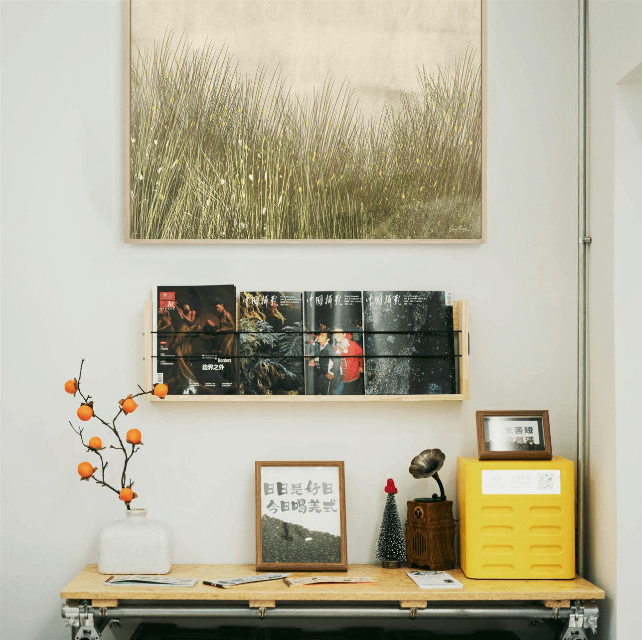 Wall  created by oam studio with framed artwork, books, and decorative items in a room setting.