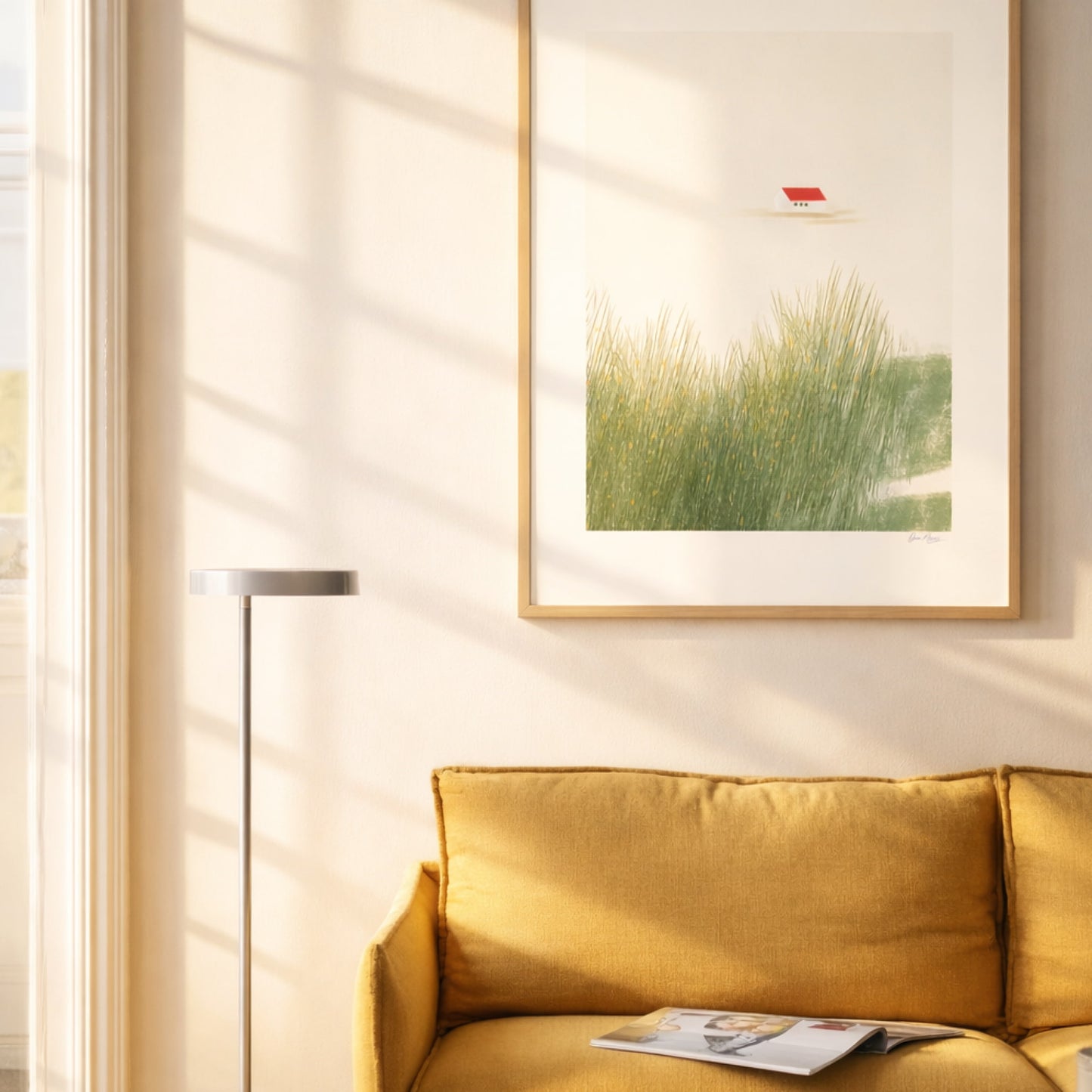 Still Home art print in a light wood frame in a bright living room above a yellow sofa, OAM Studio